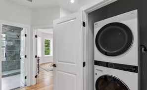 A modern laundry room with stacked washers and dryers, a glass shower enclosure, and a view of the outdoors. - 4 bedrm sleeps 14 people NW DC parking w/EV (Washington)