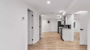 Eine moderne Küche mit weißen Schränken und Holzboden.