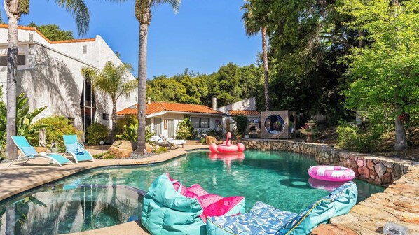 A pool area with lounge chairs, a hot tub, and a stone wall. - Private Malibu Escape w/ Guest House, Fire Pits & Mountain Views The Malibu Retreat by Avantstay (Calabasas)