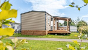A mobile home with a deck and a covered porch.