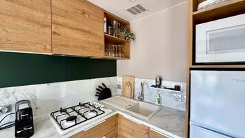 Fridge, microwave, coffee/tea maker, cookware/dishes/utensils