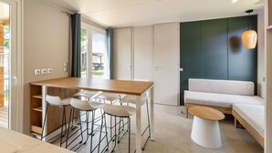 Una cocina moderna con comedor, un sofá y una lámpara colgante.