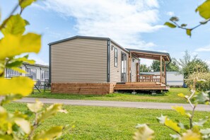 A mobile home with a deck and a covered porch.
