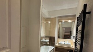 Een kleine badkamer met toilet, bad en wastafel.