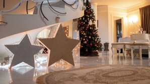 Uma escadaria imponente decorada com árvore de Natal e estrelas.