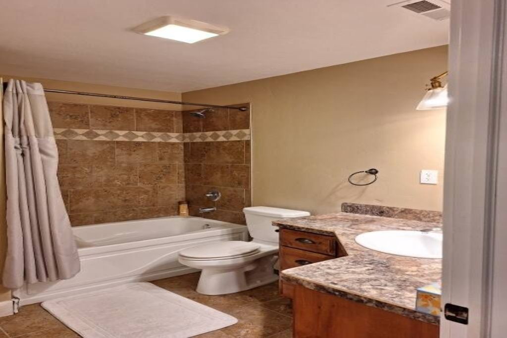 Ein Badezimmer mit einer Badewanne, Toilette und Waschbecken.