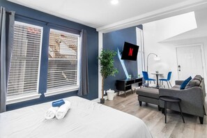 Une chambre d’hôtel moderne équipée d’un lit, d’un bureau, d’un canapé et d’une télévision.