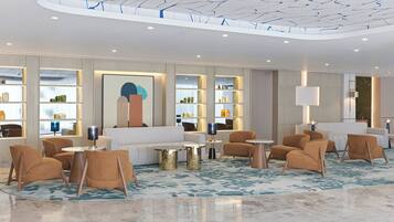 A modern lobby with a curved ceiling, seating areas, and a central coffee table.