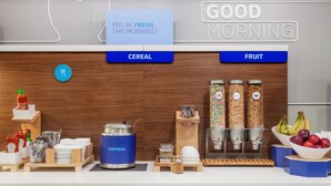 A breakfast station with cereal and fruit options, a coffee maker, and condiments. - Holiday Inn Express & Suites Jonesboro by IHG (Jonesboro)