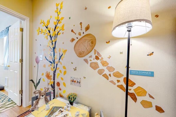 A dedicated children's play area with wall decals and a small activity table.