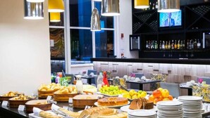 Un bufé con diversas opciones de comida y una zona de bar con botellas y un televisor.