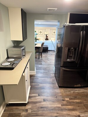 A kitchen with a built-in stove, a refrigerator, and a dining area with a table and chairs. - Tremendous apartment in Fairfield for a cozy getaway (Fairfield)