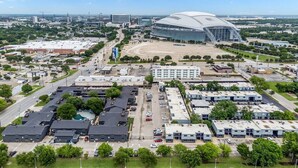 Vista aerea di uno stadio con un ampio parcheggio e edifici circostanti.