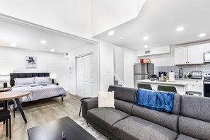 Eine moderne Wohnung mit Schlafzimmer, Wohnzimmer und Küchenzeile.