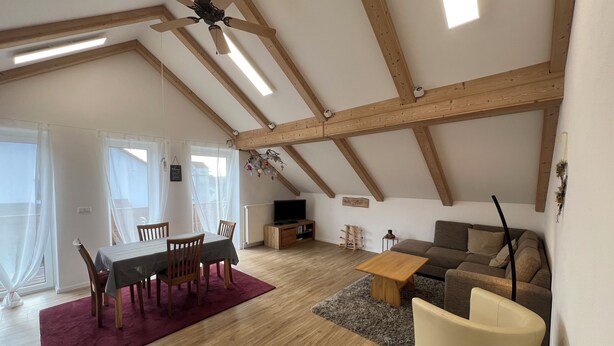 A spacious loft with a dining area, a sofa, a TV, and a ceiling fan. - Cozy apartment near the Bavarian Forest – ideal for couples or families (Neukirchen, Alemania)