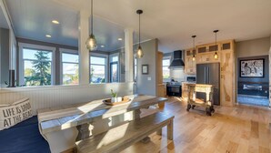 Une cuisine moderne avec des meubles en bois, un grand îlot central et des luminaires suspendus.