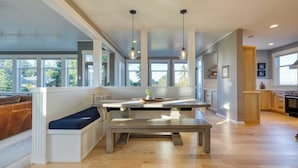 Une cuisine moderne dotée d’un îlot central, de grandes fenêtres et d’un banc intégré.