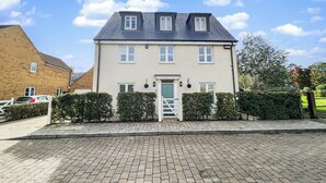 Ein zweistöckiges Haus mit Satteldach, Eingangstür und kleiner Veranda.
