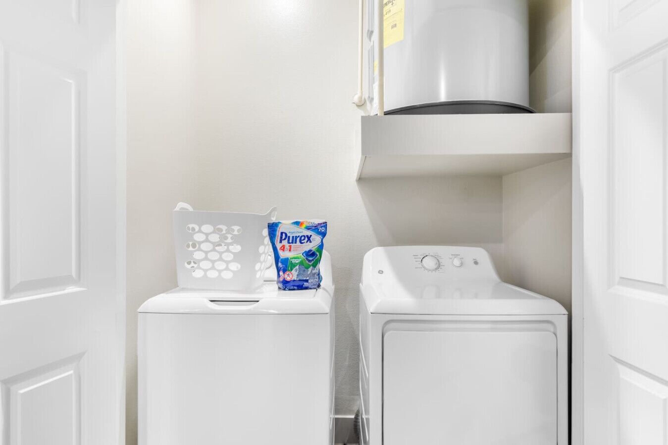 A laundry area with a washing machine, a dryer, and a detergent dispenser.