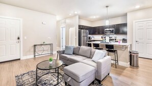 Eine moderne Wohnung mit Wohnzimmer, Küche und Essbereich.