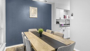 A dining area with a table, chairs, a ceiling fan, and a framed picture on the wall. - Arlington 3BR | AT&T, Globe Life, 6 Flags, Parking (Arlington)