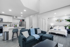 A modern apartment with a kitchen, a dining area, a living room with a sofa, and a bedroom with a bed. - 5 Min to Love Field | Gated+Guard | 2BR | Parking (Dallas)
