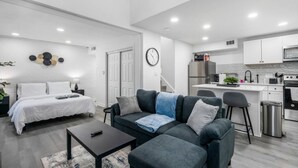 A modern apartment with a living room, a separate bedroom, a kitchenette, and a dining area. - 5 Min to Love Field | Gated+Guard | 2BR | Parking (Dallas)