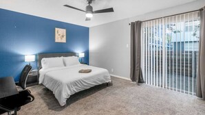 A bedroom with a bed, a desk, a chair, a ceiling fan, and a window with curtains. - Arlington 1BR | AT&T, Globe Life, 6 Flags, Parking (Arlington)