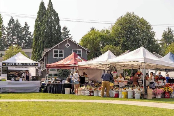 Un marché avec différents stands, dont un pour un restaurant appelé « Earthling Grill » et un autre pour un autre restaurant.