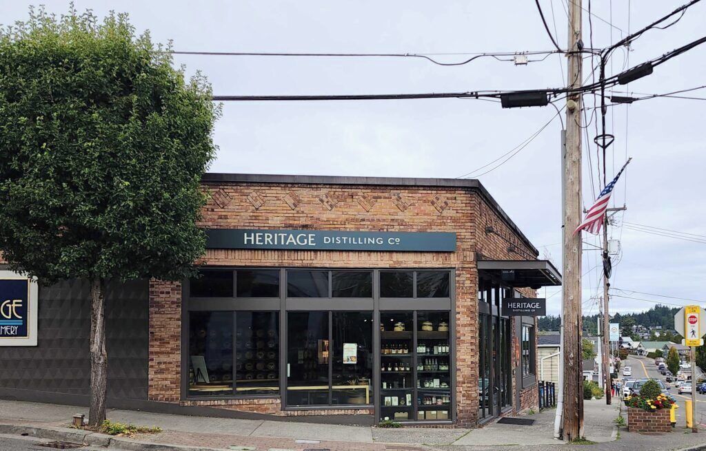 Un bâtiment en briques doté de grandes fenêtres et d’une enseigne indiquant « Heritage Distilling Co. ».