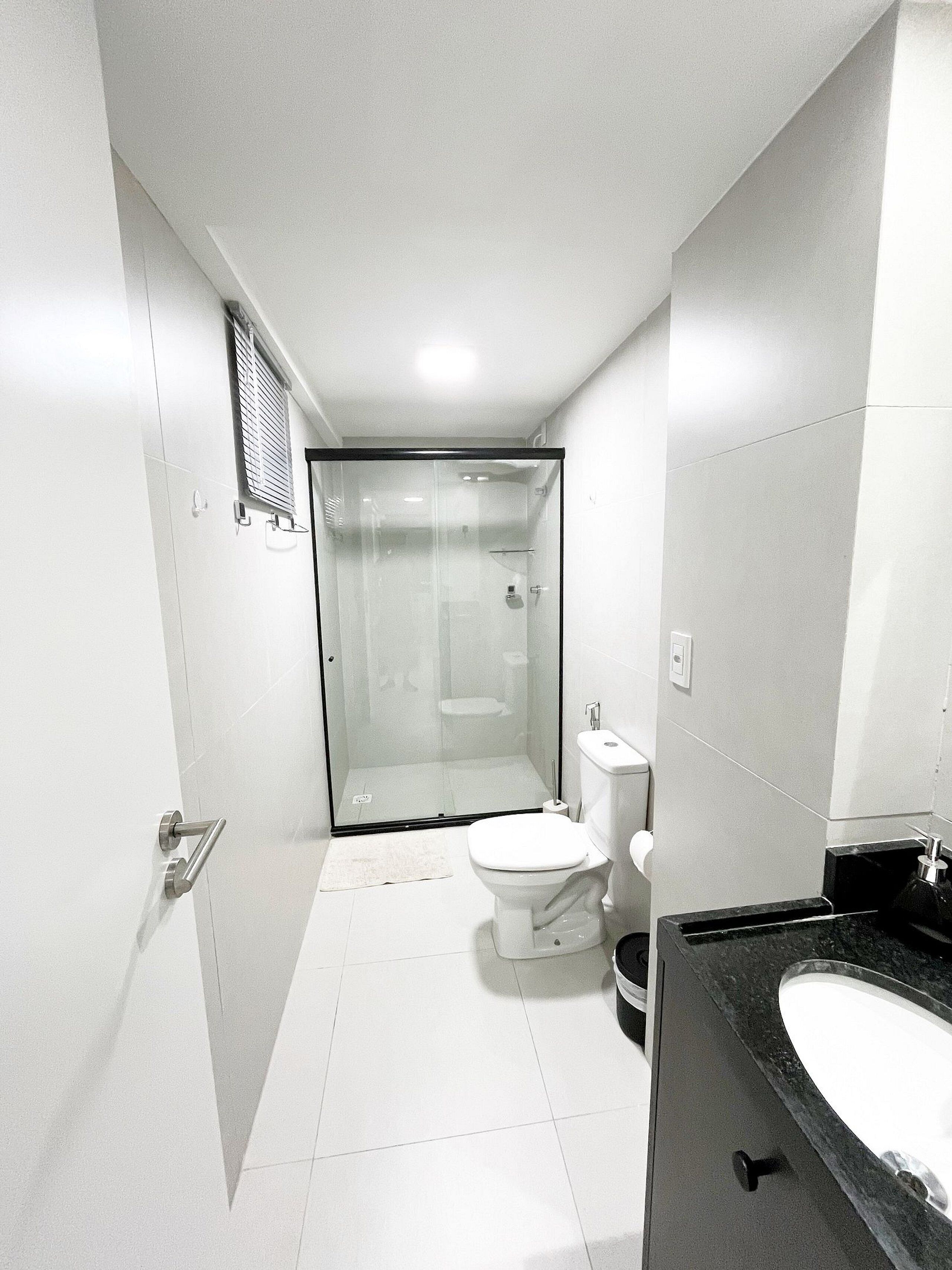 Une salle de bain moderne avec une douche à parois de verre, des toilettes et un lavabo.