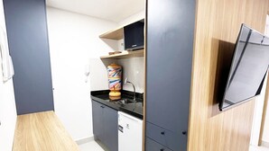 Een moderne keuken met een ingebouwde vaatwasser, een magnetron en een houten aanrecht.