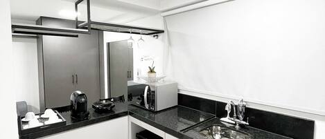 A modern kitchen with a dishwasher, a coffee maker, and a microwave.