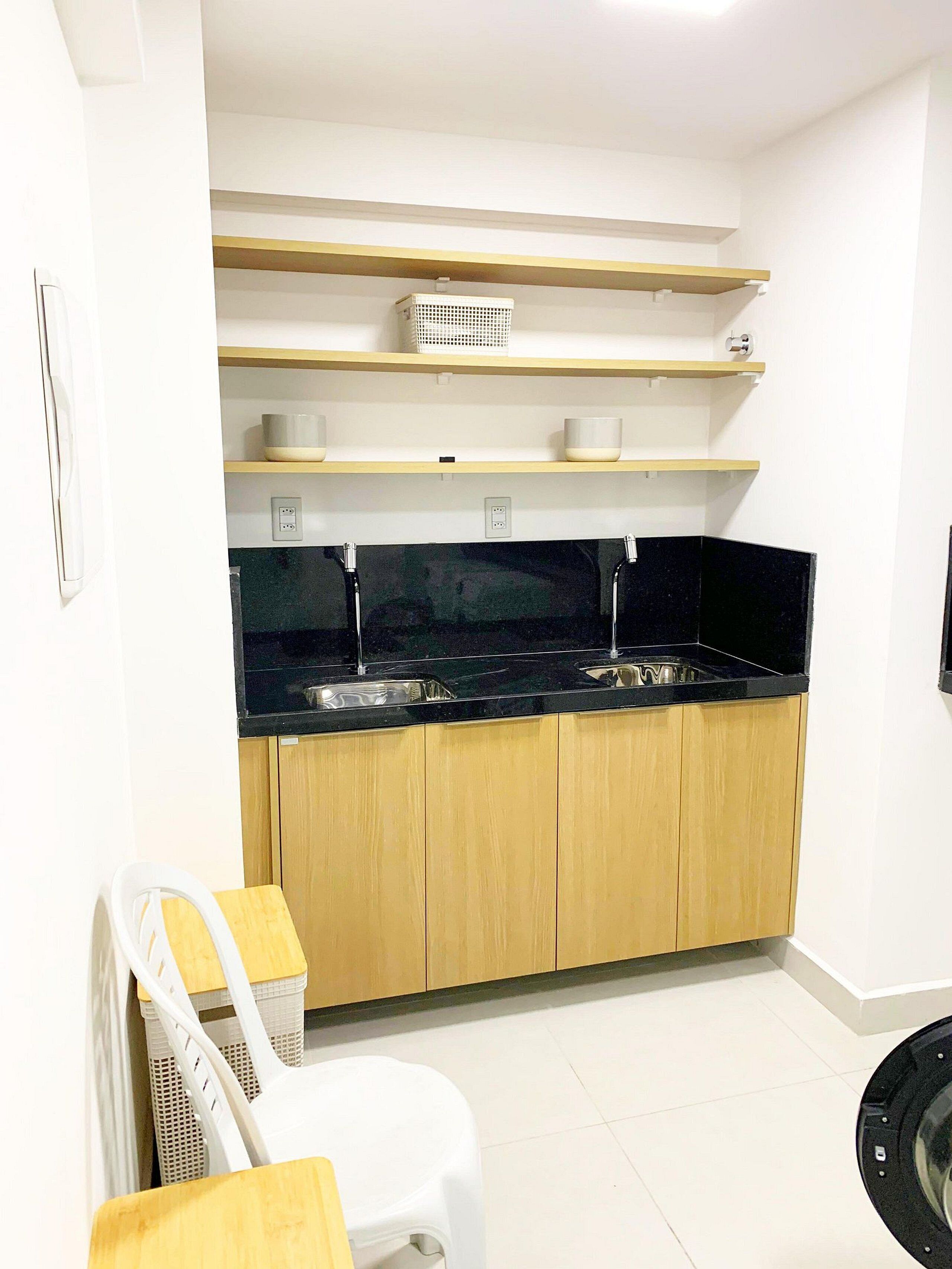 A kitchen with wooden cabinets, black countertops, and white appliances.