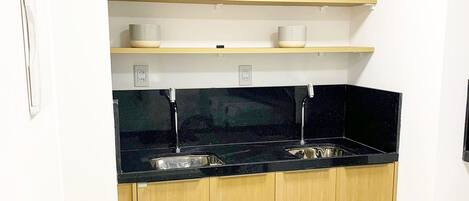 A kitchen with wooden cabinets, black countertops, and white appliances.