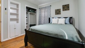 A bedroom with a bed, a ceiling fan, a wardrobe, and a window with curtains. - River Oaks Retreat- Walkable to Goodfellow AFB (San Angelo)