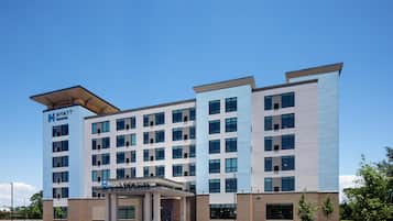 A modern hotel building with a flat roof, multiple floors, and a central entrance.