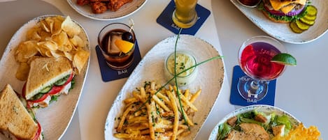 A variety of food items on a table, including sandwiches, fries, and a burger.