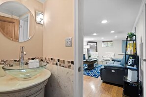 Un baño moderno con un lavabo de vidrio y un espejo.