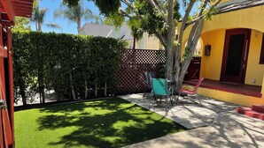 A backyard with artificial grass, a patio area, and a wooden fence. - This property is no longer available. 1 Bedroom / 1 Bath Duplex near Melrose (Los Angeles)