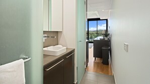 Une salle de bain moderne avec un lavabo, un miroir et des placards.