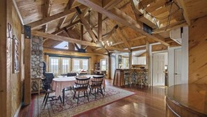 Un intérieur spacieux en bois comprenant un coin repas, une cuisine et un bar.