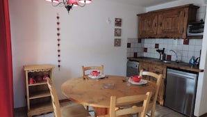 Eine kleine Küche mit Holzausstattung, einem eingebauten Backofen und einem Geschirrspüler.