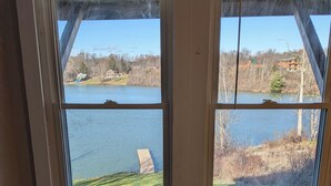 A room with two windows overlooking a lake and a grassy area. - Lakefront Haven w/ 50-ft Dock 4BR Near Punderson Park & Amish Country EV Charger (Newbury)