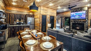 Un accogliente interno in stile baita, con zona pranzo, cucina e soggiorno.