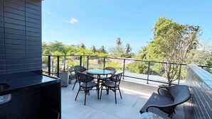 A balcony with a grill, a round table, and four chairs. - Dutra Ocean Flat By DayByDay (Joao Pessoa)