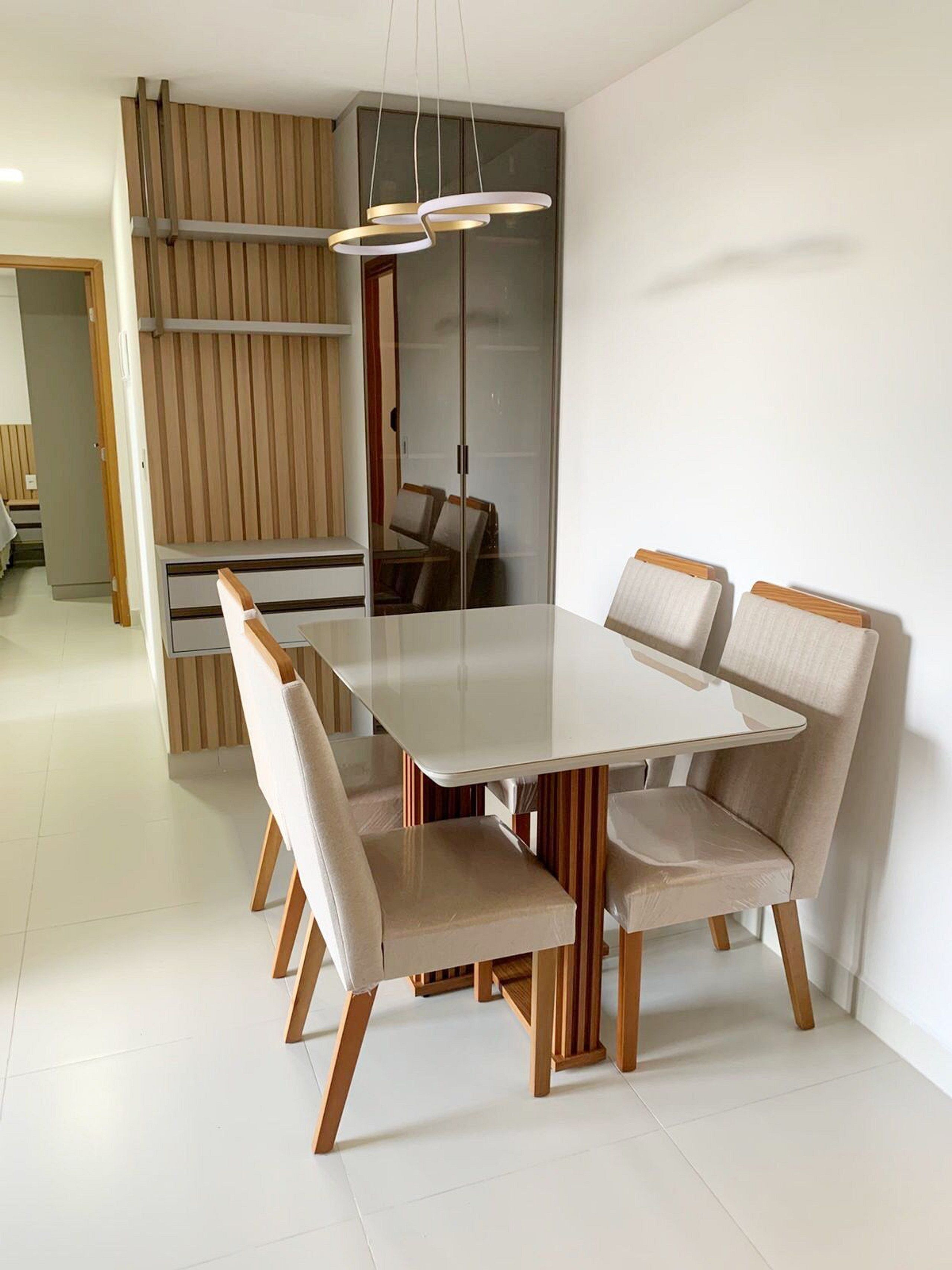 Un espace repas moderne avec une table rectangulaire et six chaises rembourrées.
