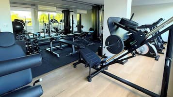 A gym with various exercise equipment including treadmills, weight machines, and free weights.