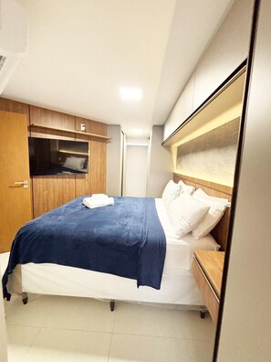 A compact hotel room with a single bed, a wooden wardrobe, and a small bedside table. - Dutra Ocean Flat By DayByDay (Joao Pessoa)