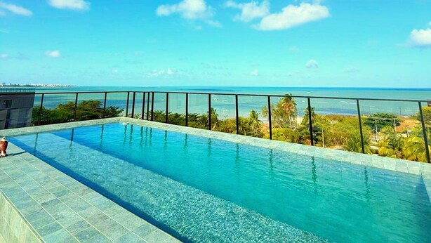 A clear blue sky with a pool and a view of the ocean. - Dutra Ocean Flat By DayByDay (Joao Pessoa)